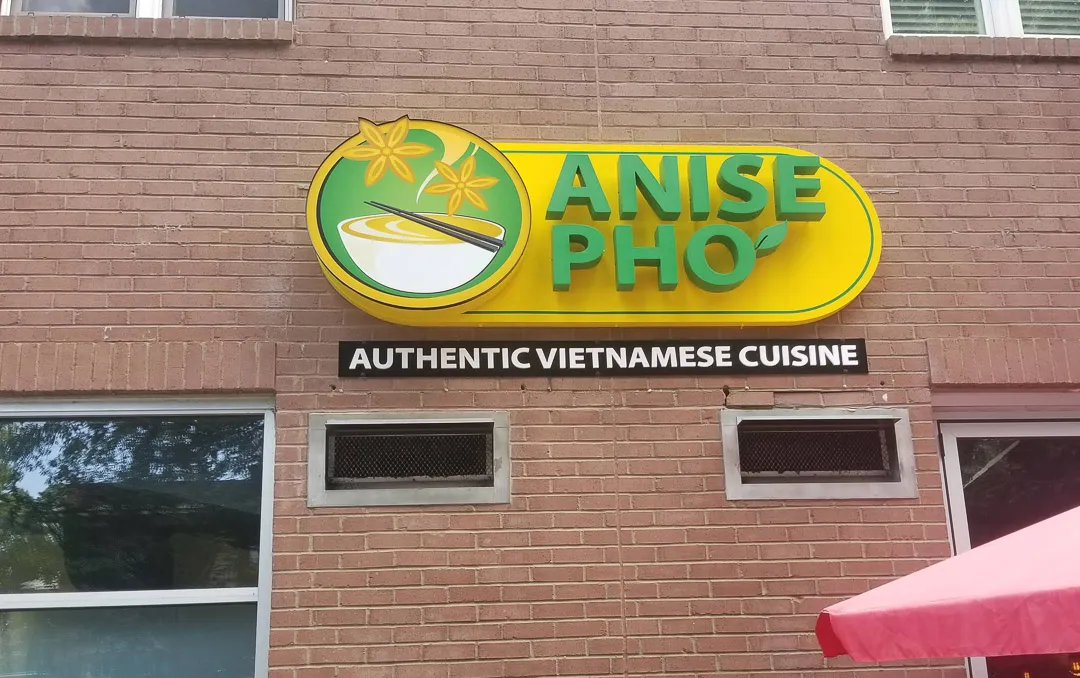 Lit logo and letters on brick for Anise Pho
