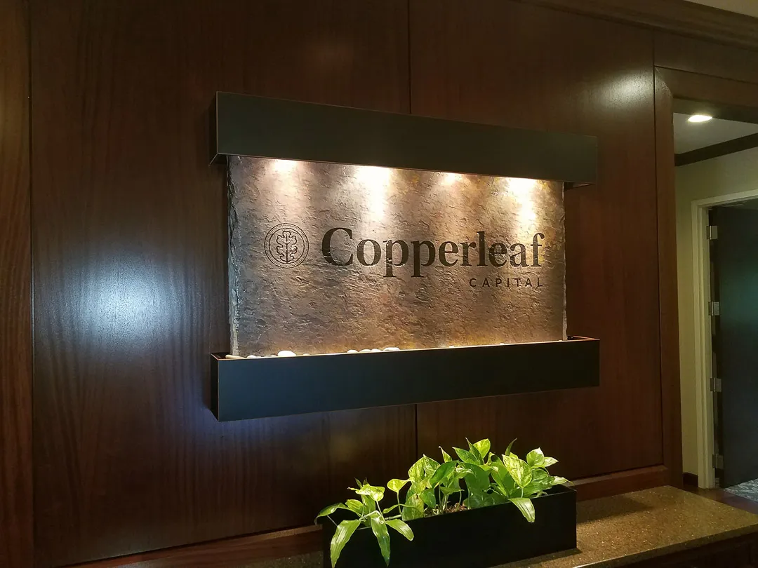 Lit lobby sign on water feature for Copperleaf