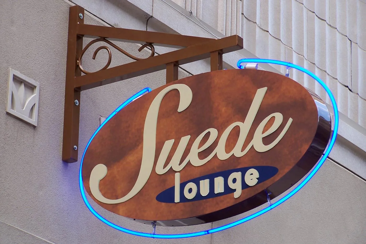Oval projecting sign with neon ring for Suede Lounge