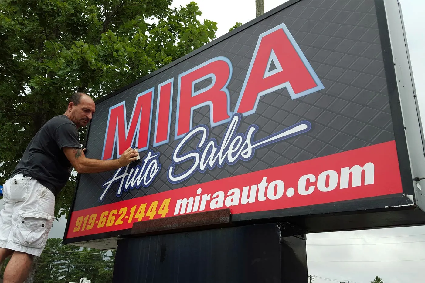 Large cabinet face being installed for Mira Auto Sales